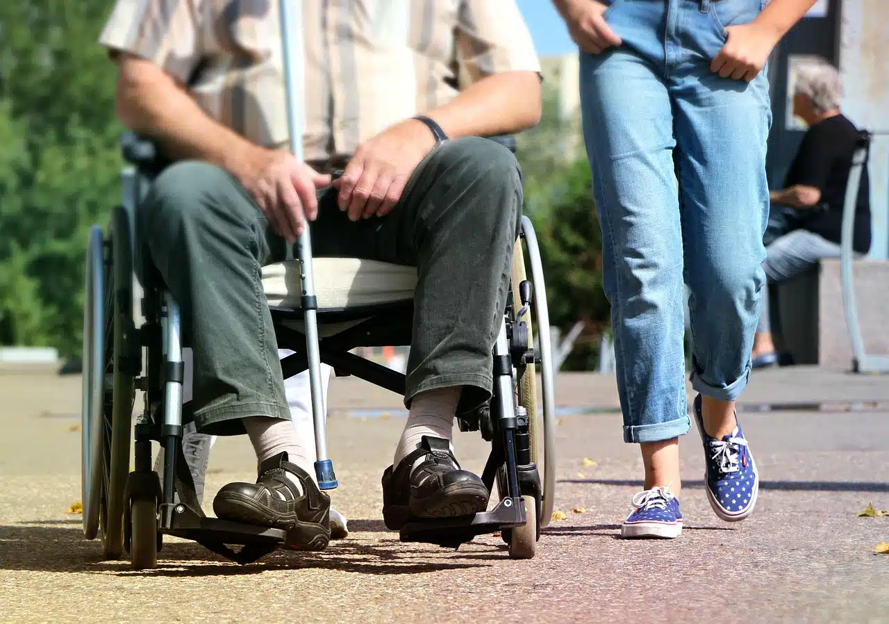 A person in a wheelchair beside their caregiver