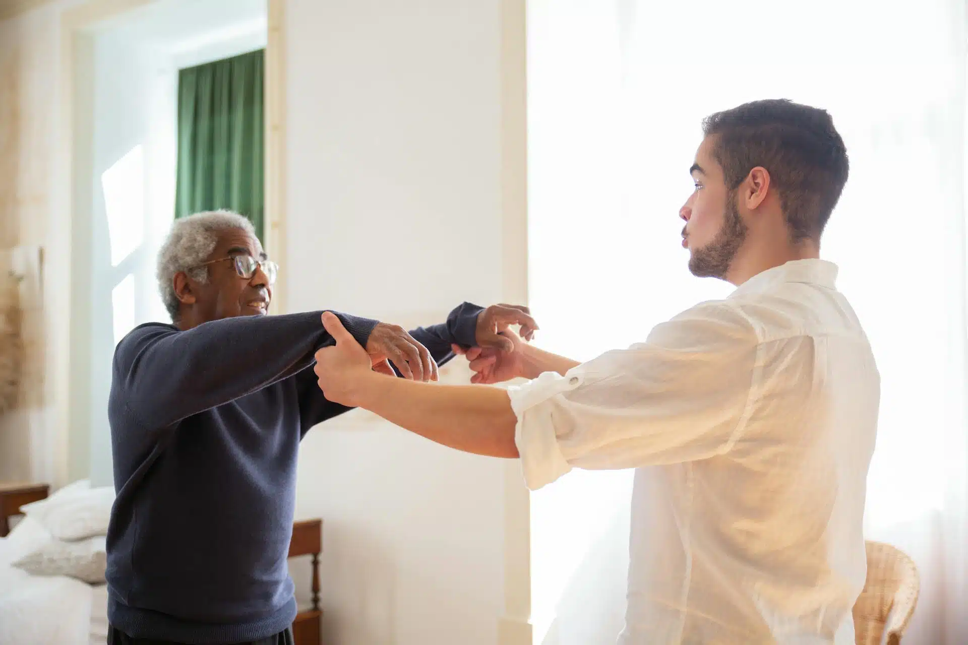 A male caregiver attending to senior patient
