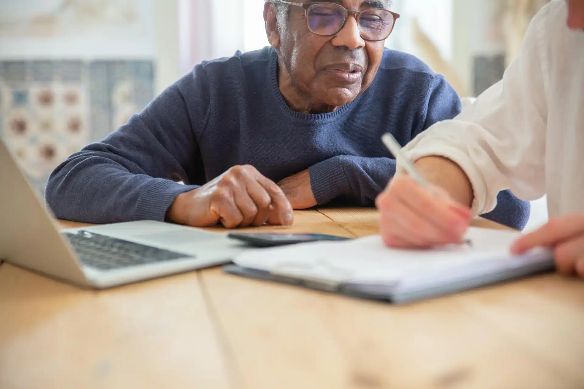 Older man writing a piece of document