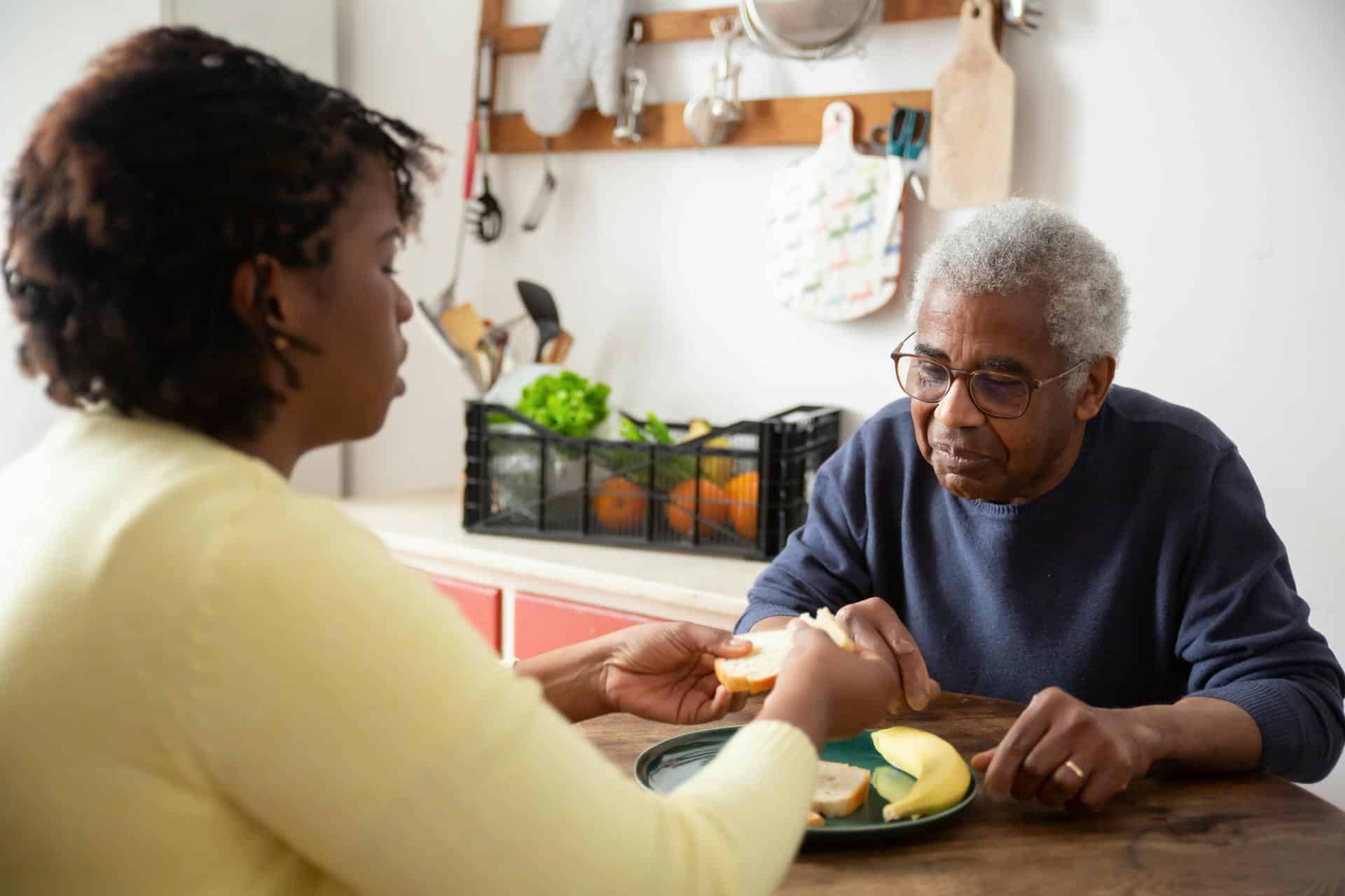 A carer in yellow shirt assisting older participant