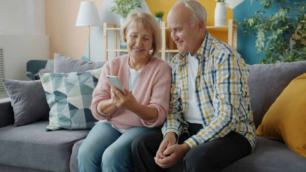 An elderly couple looking at a smartphone