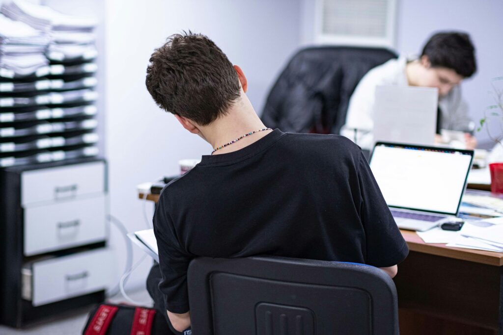 Male caregiver with their back turned using computer