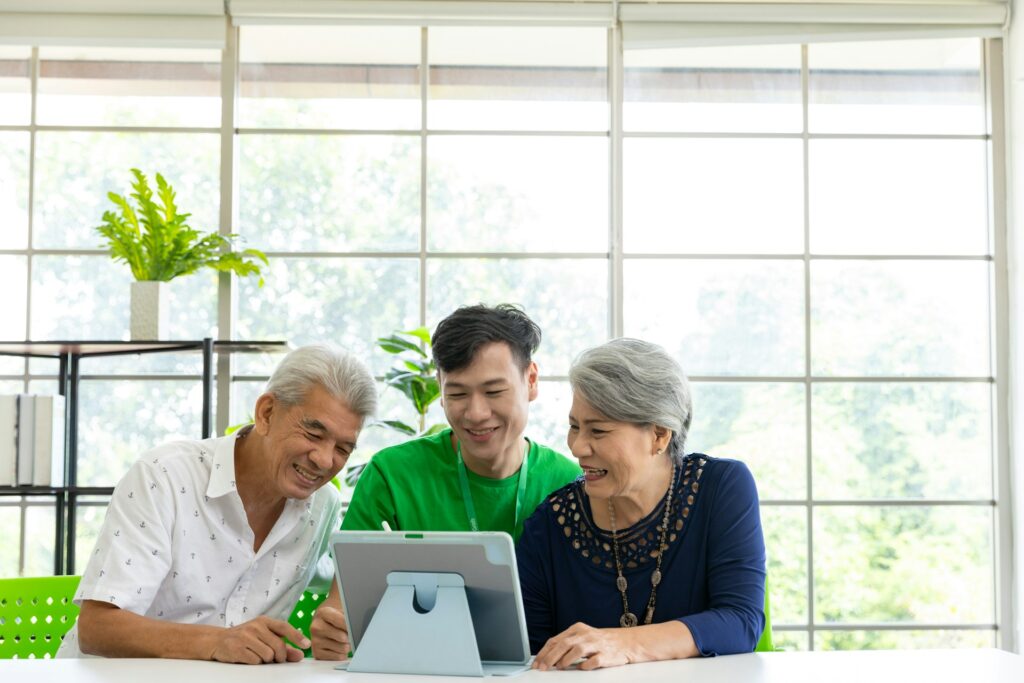 One young carer and two seniors using computer