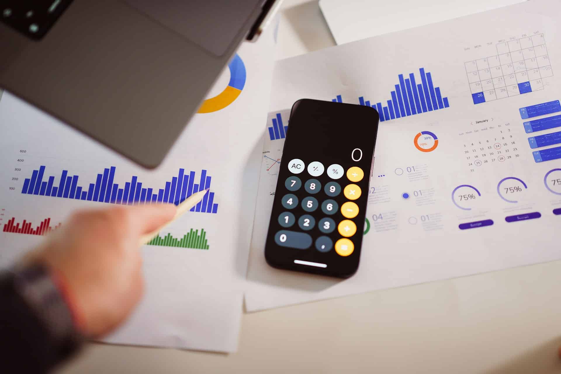 Calculator app opened on an iPhone on top of charts