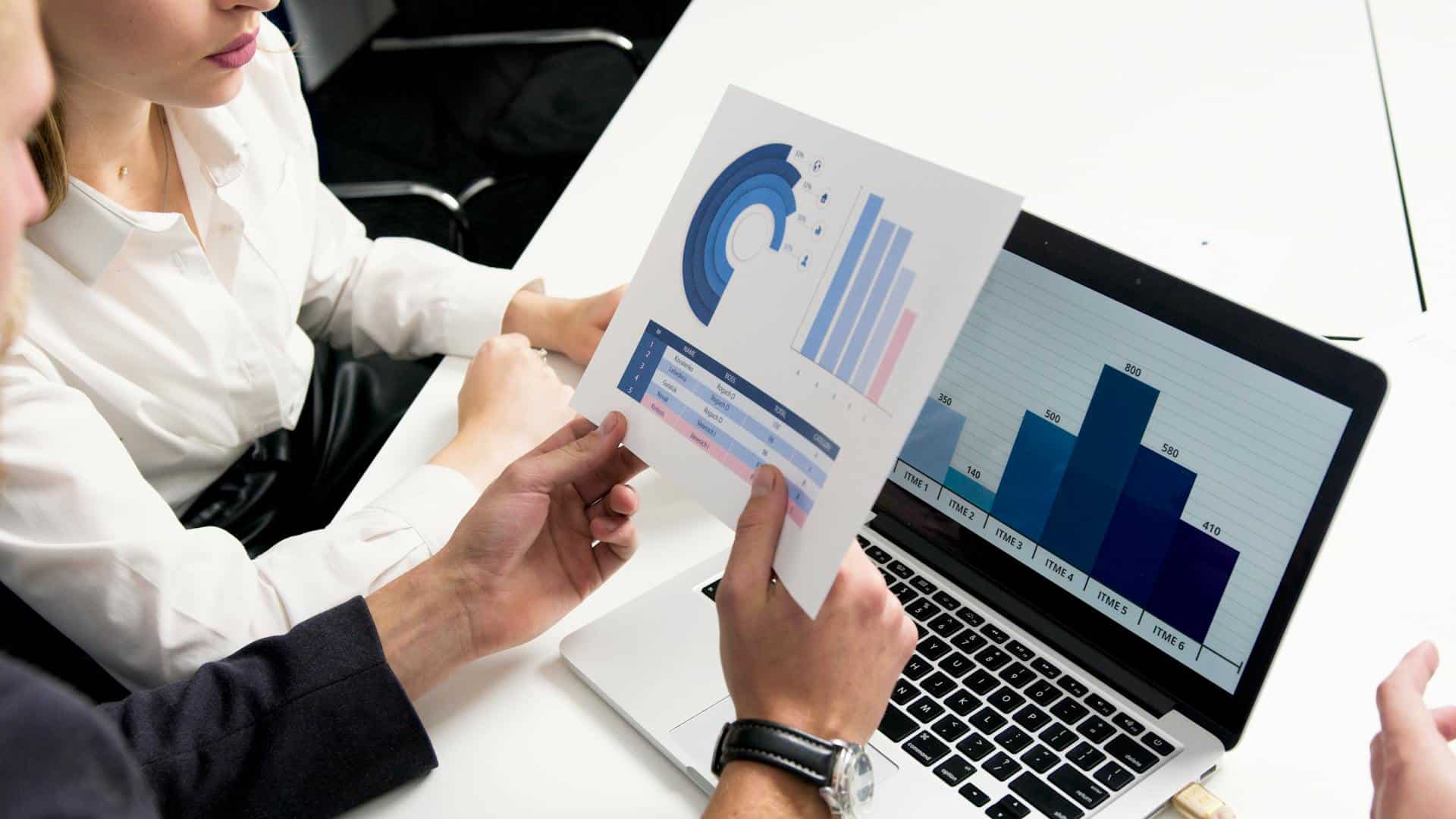 Two professionals looking at a spreadsheet