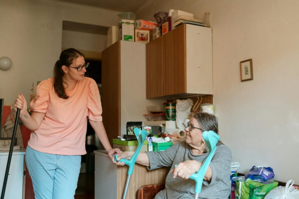 Carer in pink shirt assisting elderly wheelchair user