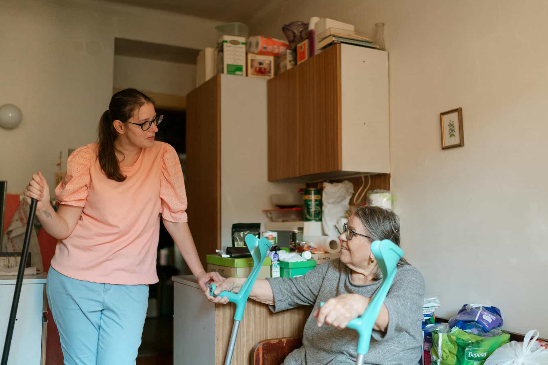 Carer in pink shirt assisting elderly wheelchair user