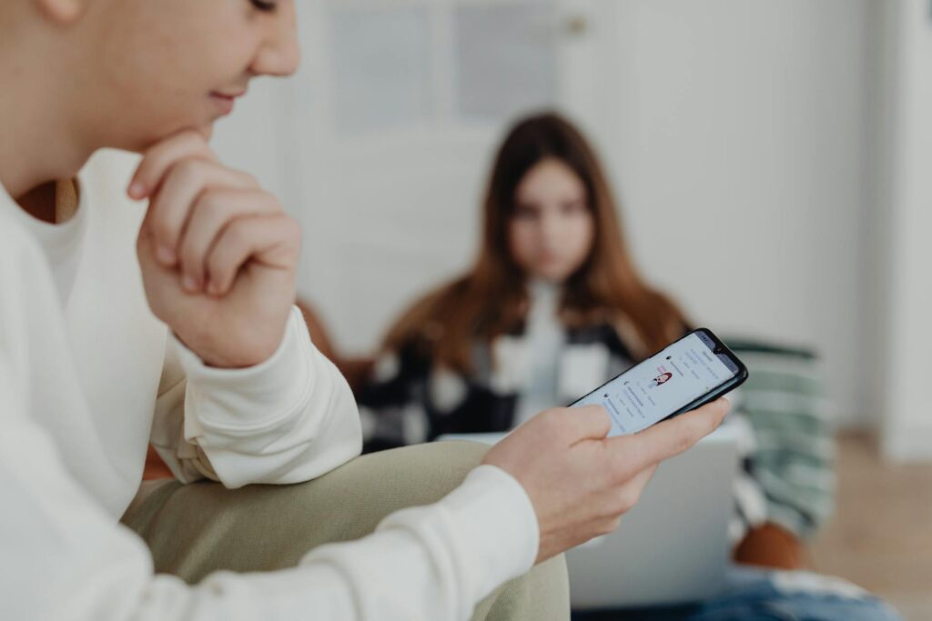 Carer using cellphone in front of another person