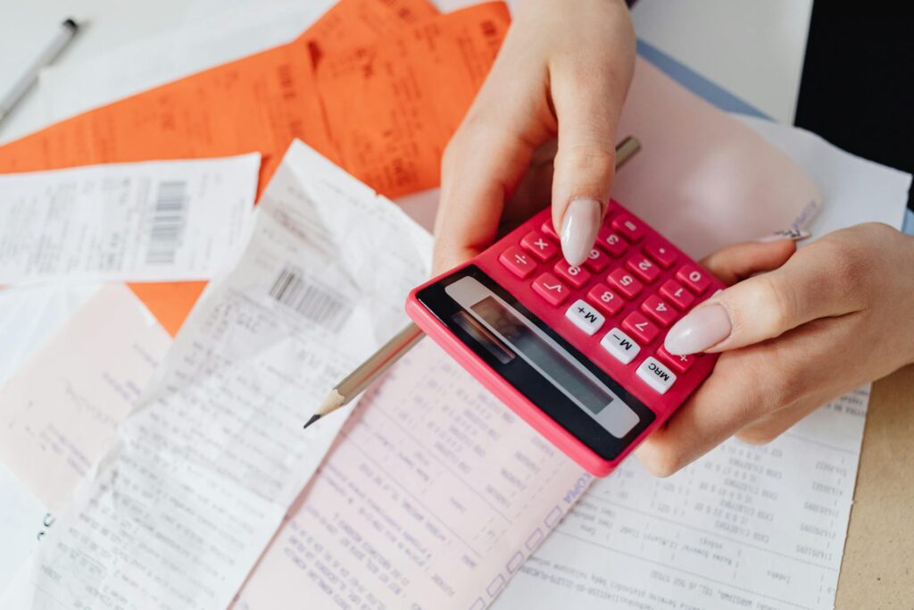 Person using a calculator on top some sheets