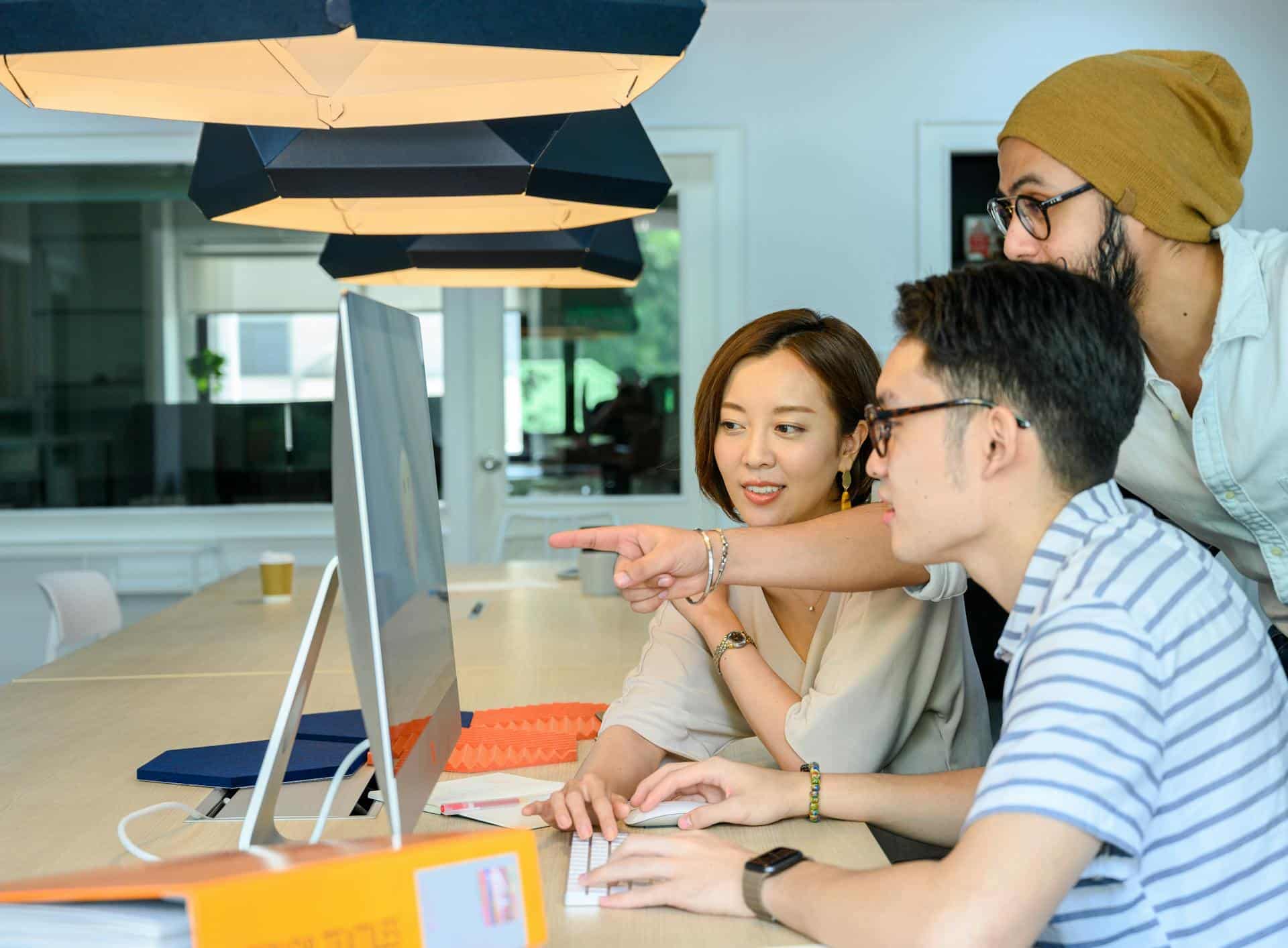 Three people looking at a single computer screen