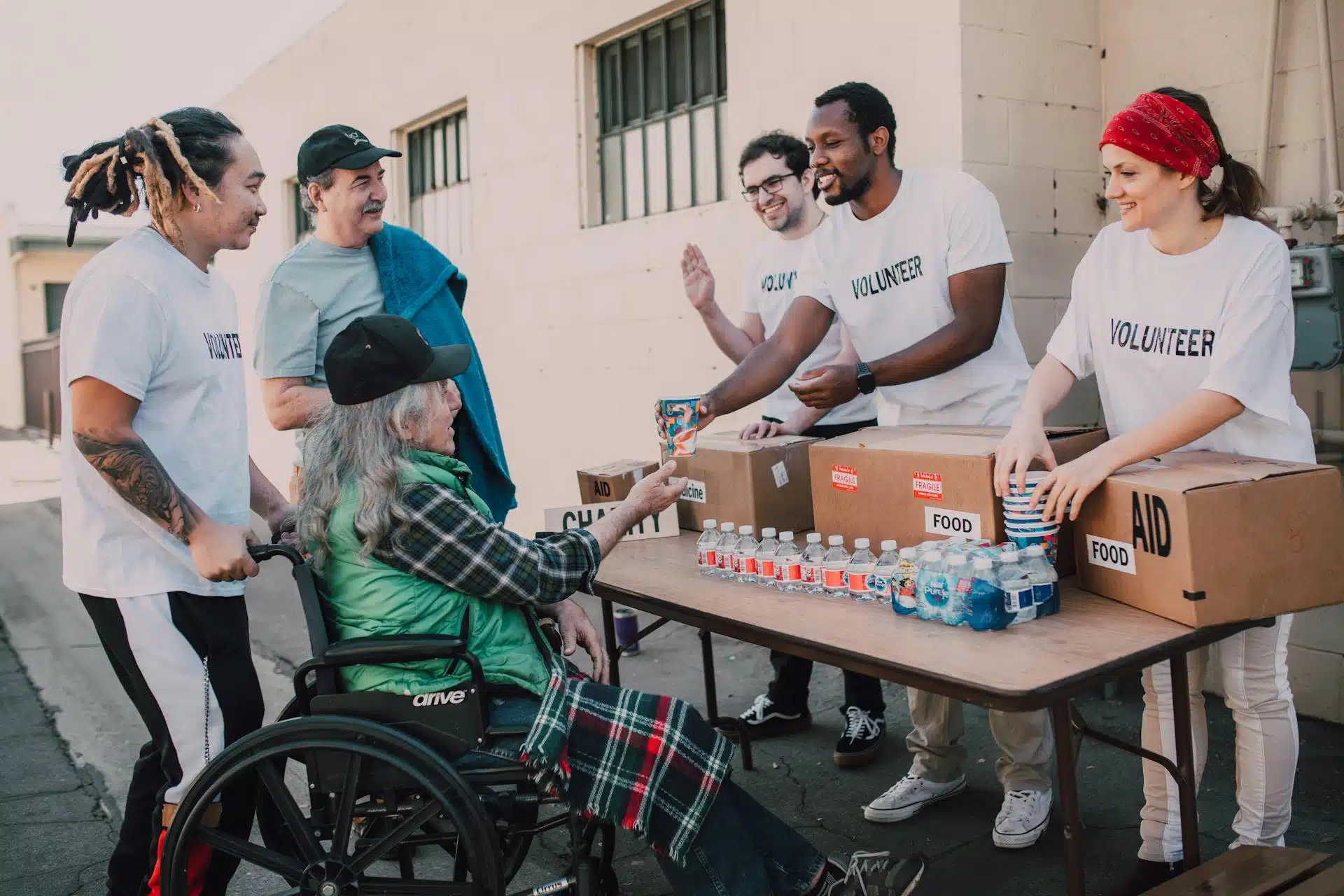 A group of volunteers helping a wheelchair user