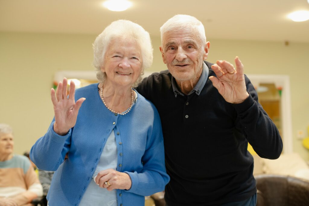 two seniors waving at you