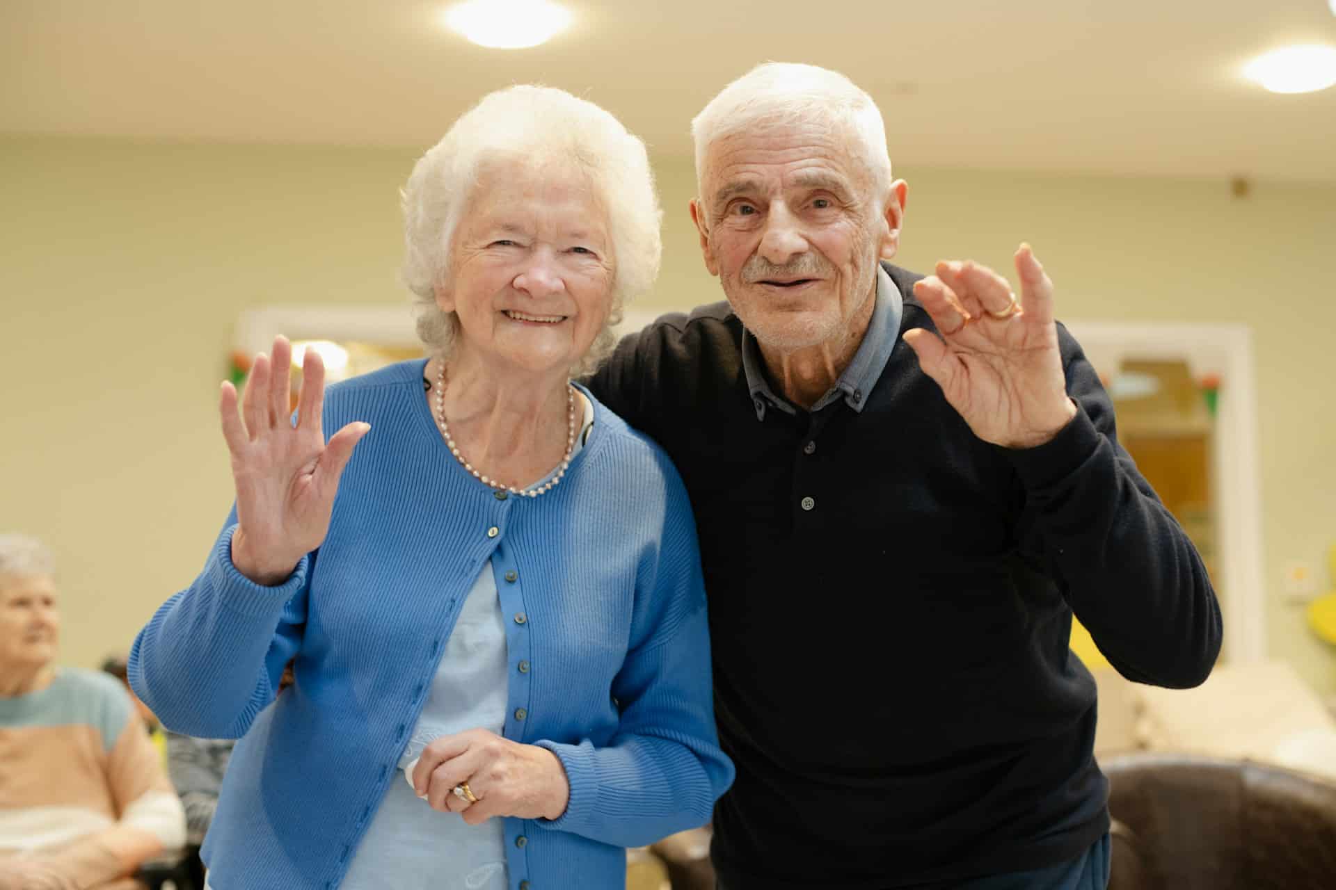 two seniors waving at you