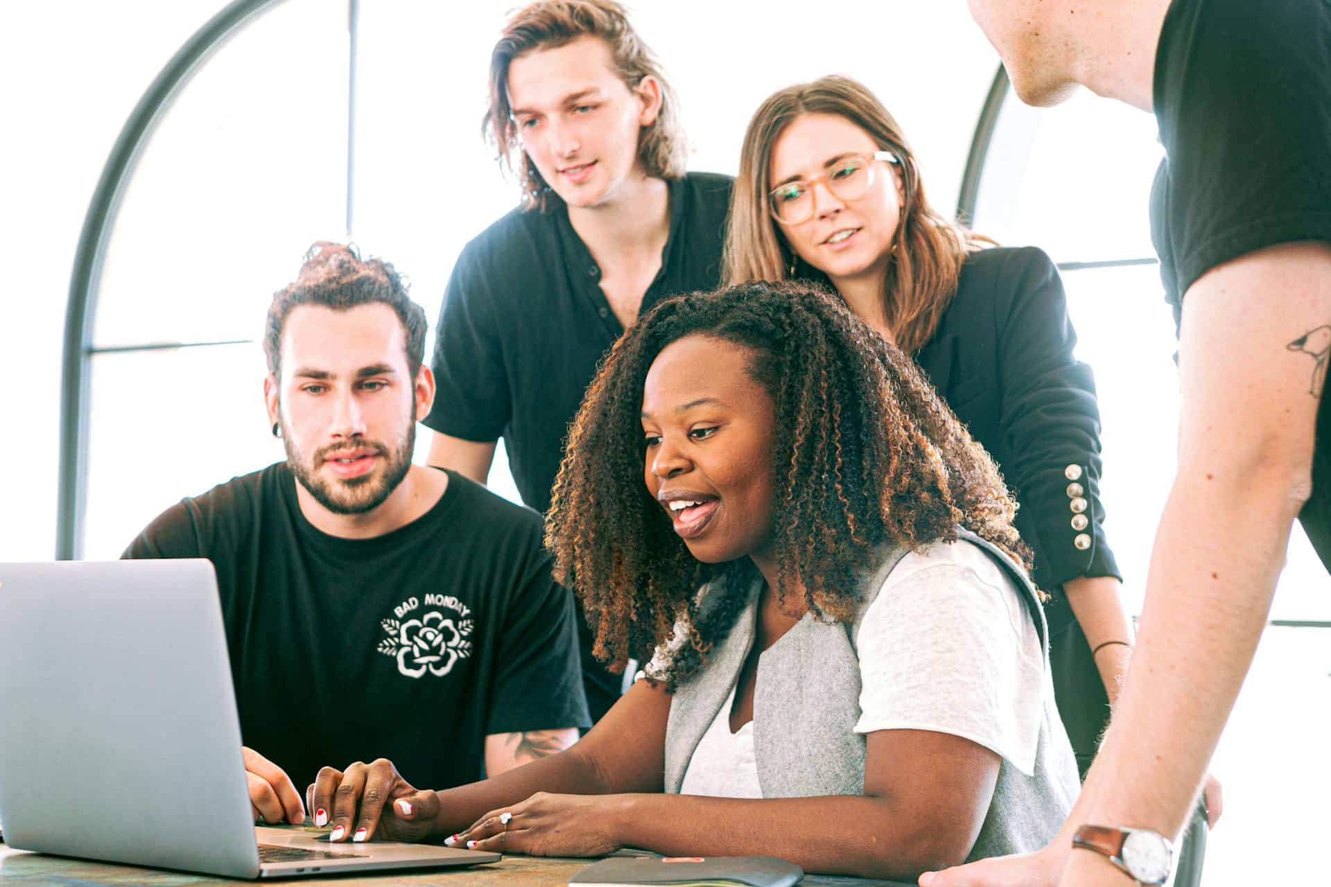 Group of workers collaborating on a laptop