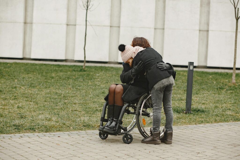 A carer hugging a wheelchair user