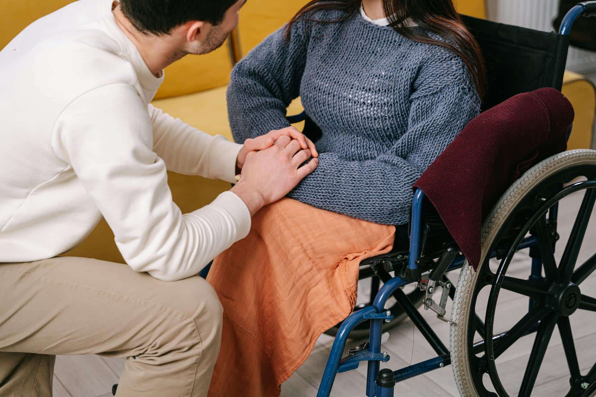 Caregiver with their hands on top of the hands of a wheelchair user