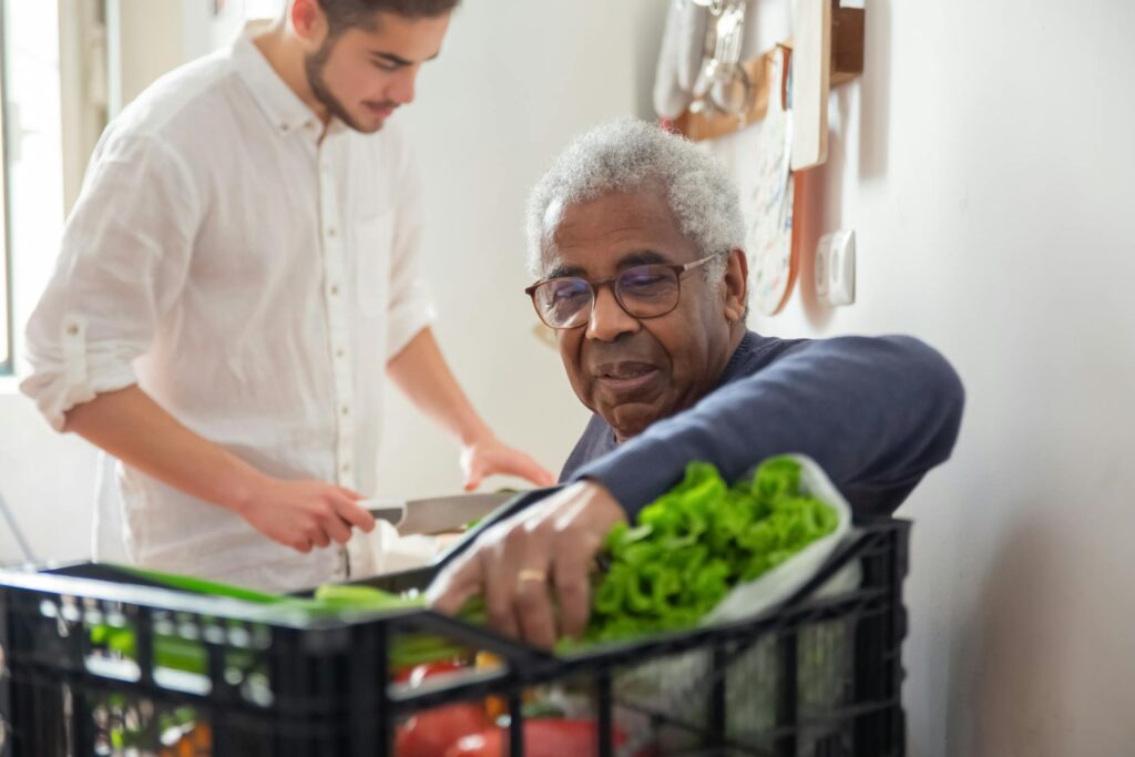 Carer cooking with his senior client