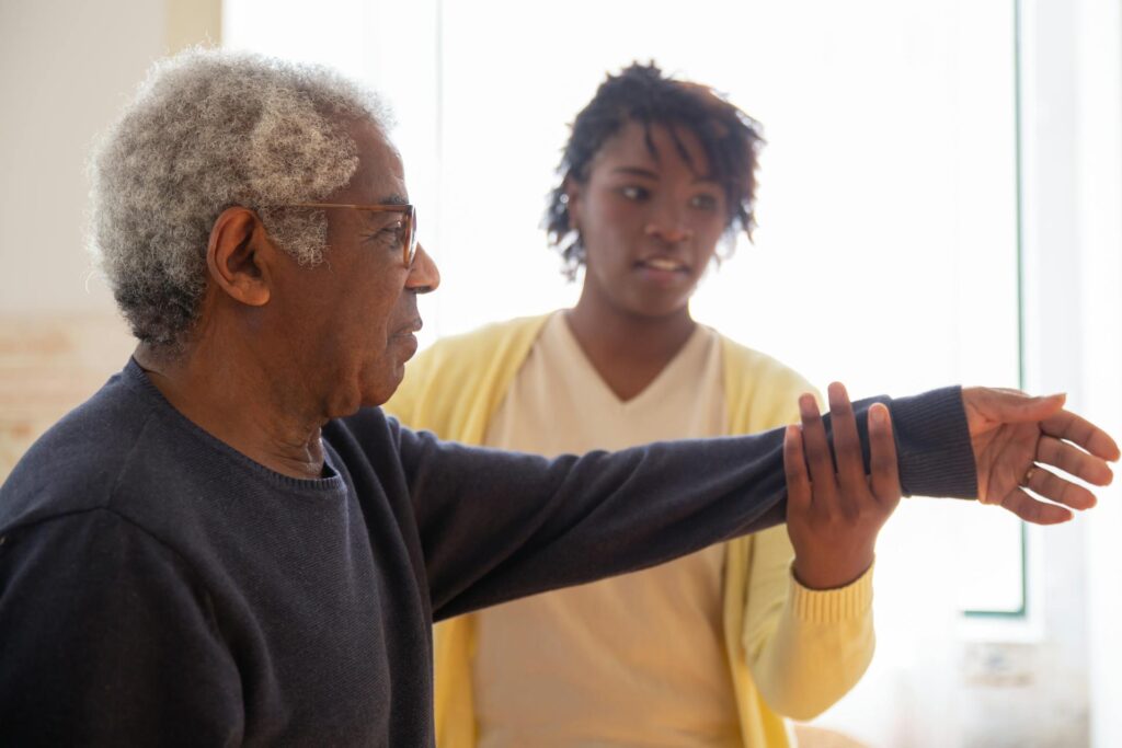 Carer helping older patient with mobility