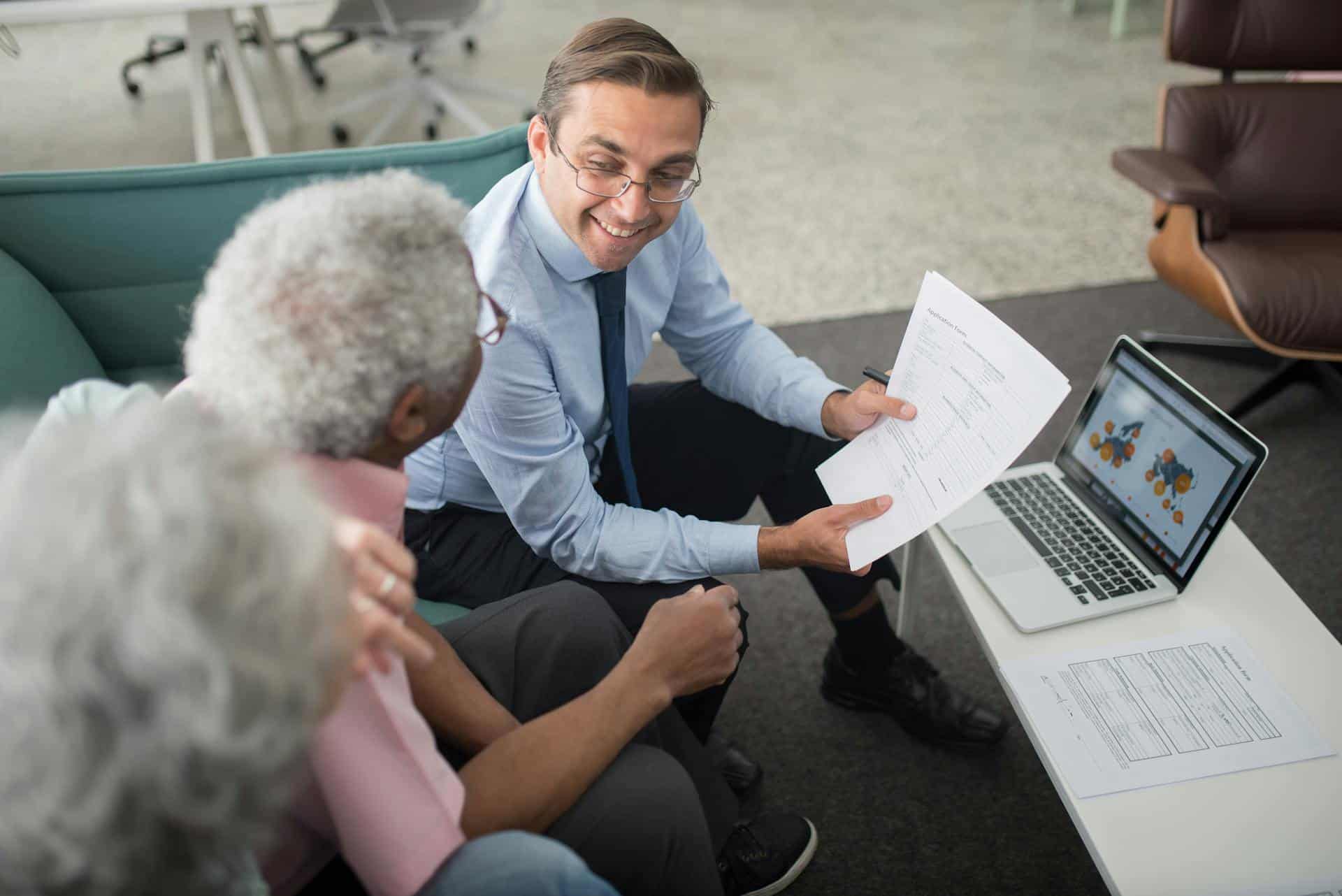 A carer explaining documents to senior clients