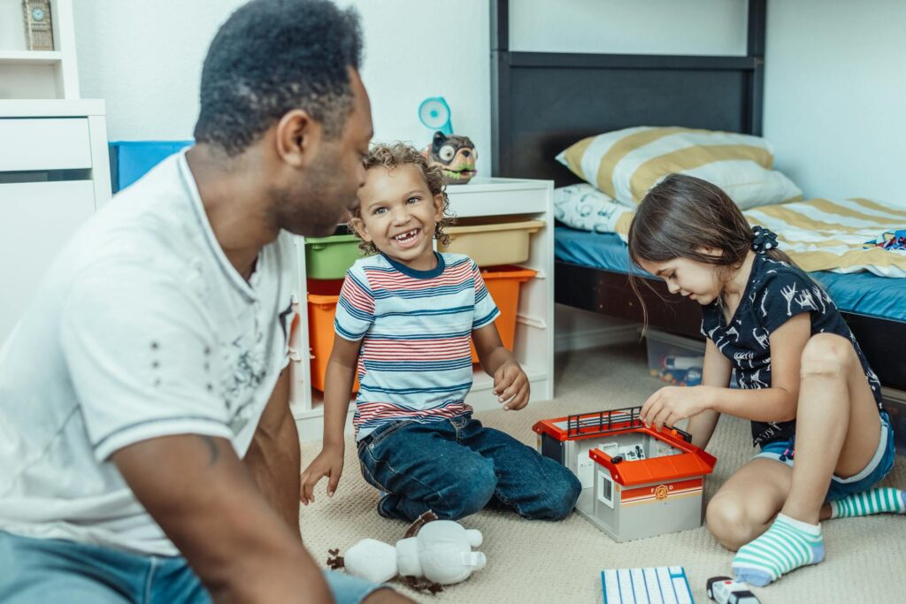 Carer looking after two children playing