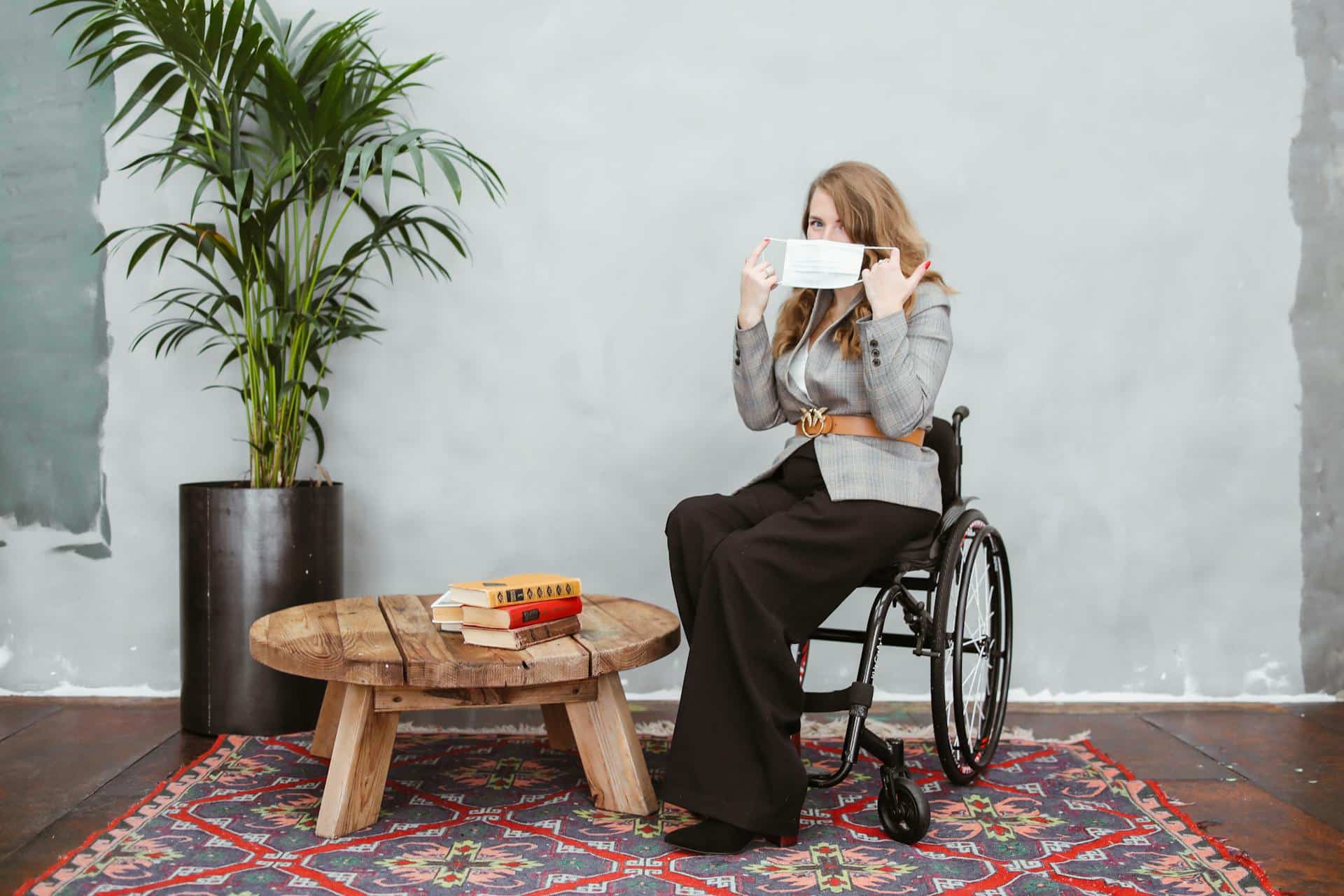 Wheelchair user putting on her mask
