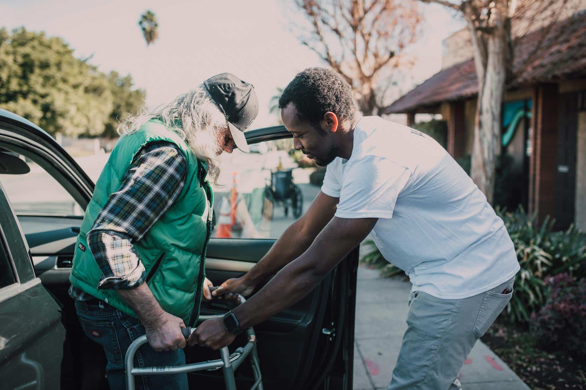Carer assisting client outside of his car