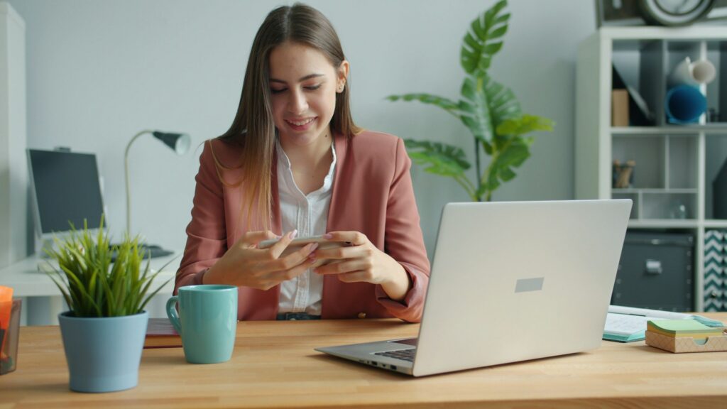 office worker looking at phone while working