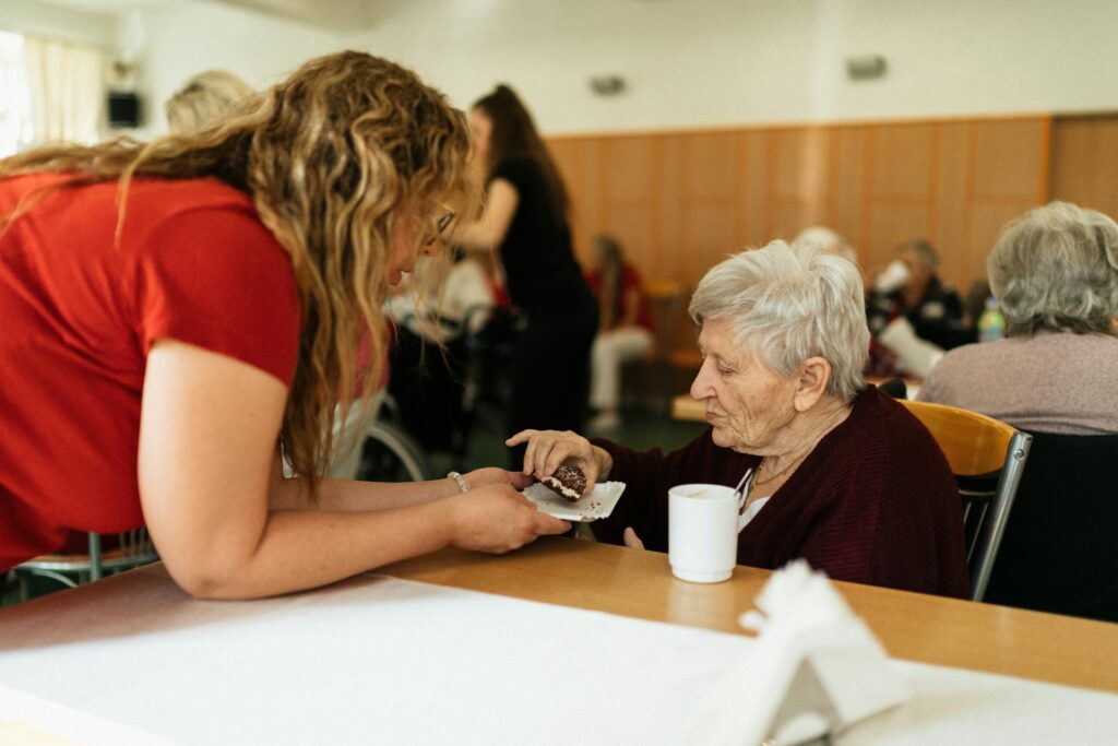 Caregiver assisting older patient with writing