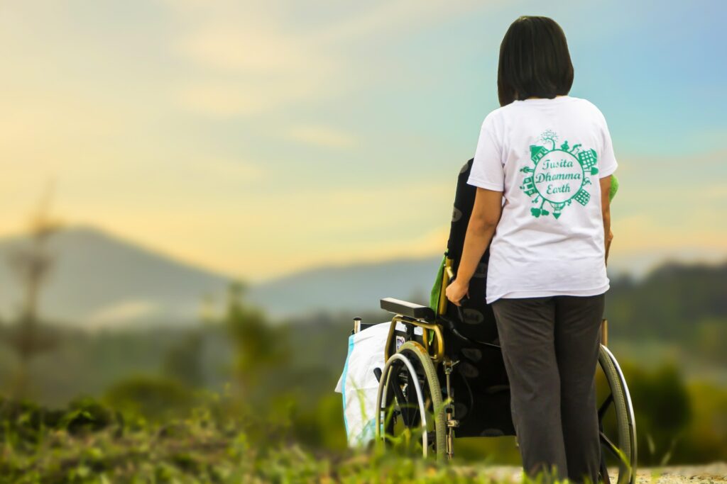 Caregiver pushing a wheelchair user